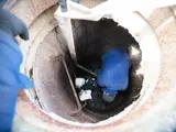 Worker cleaning the sewer hatch